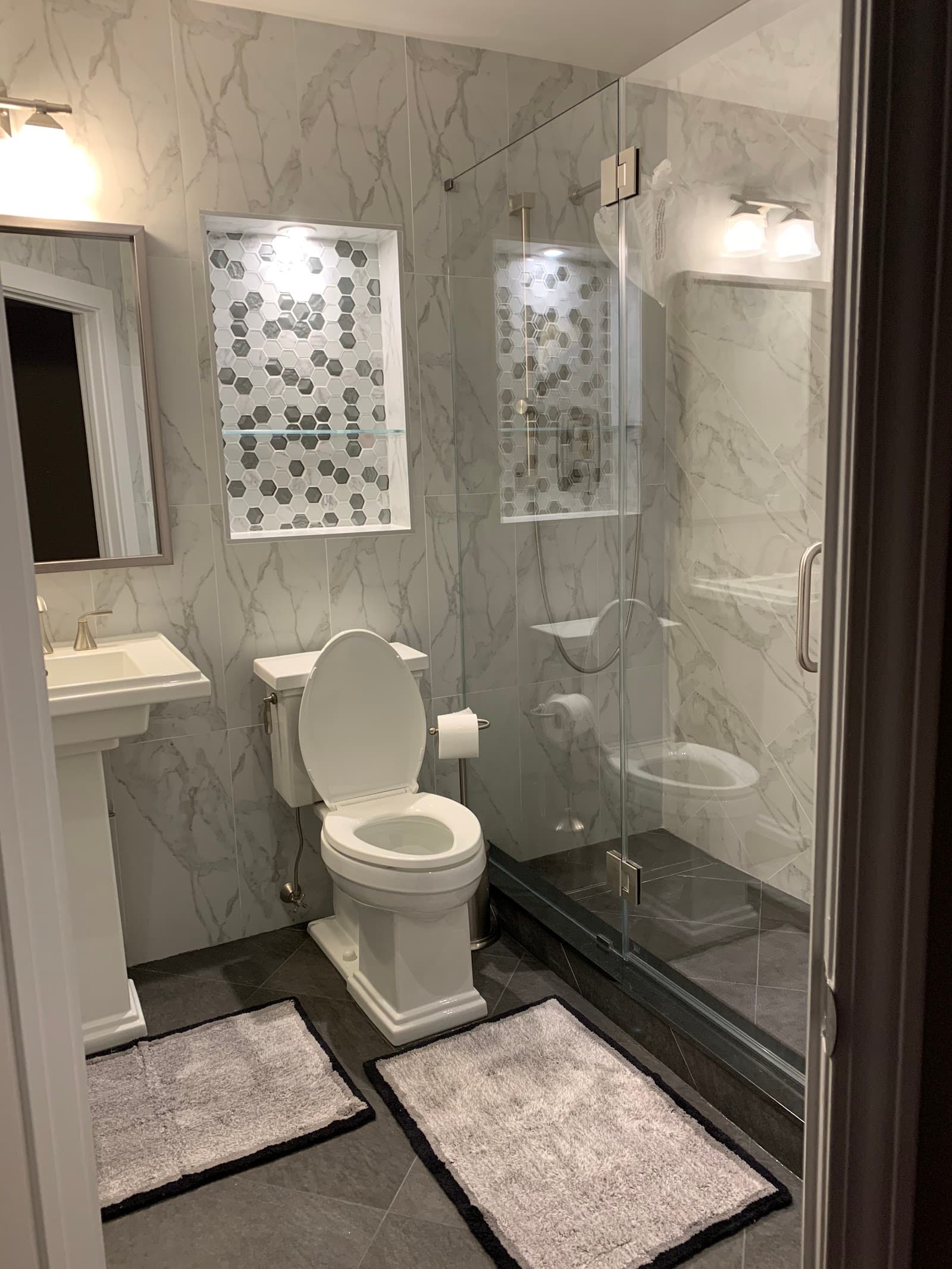 Marble bathroom remodel with a hexagon-tile shower niche